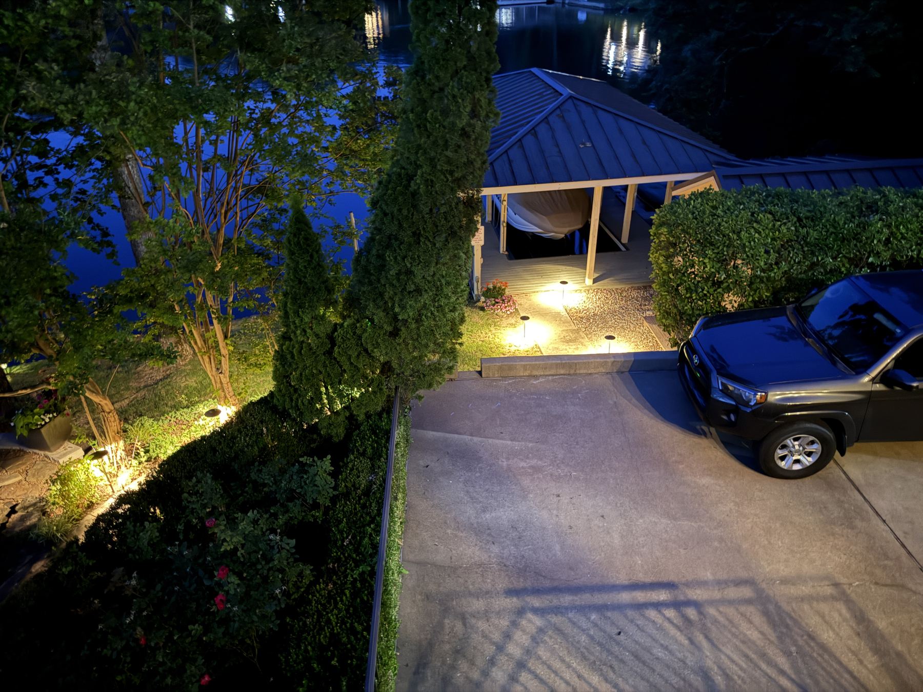 Aerial driveway and tree lighting on lakeside property